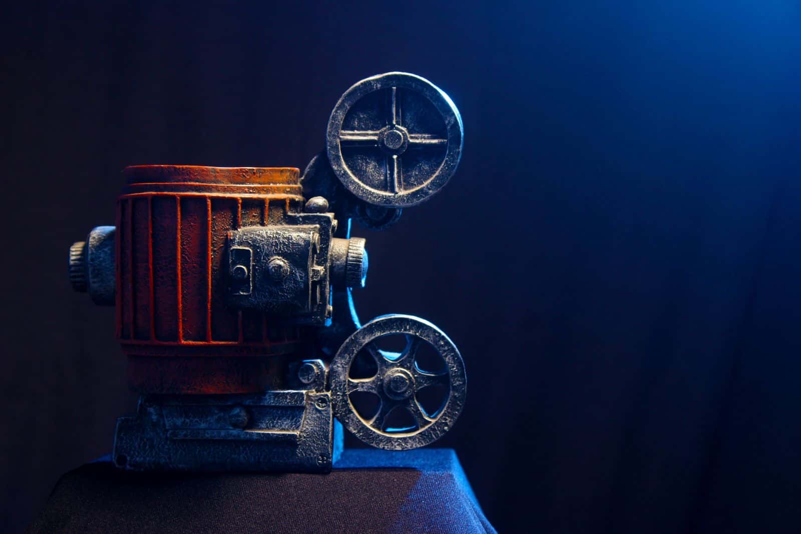 An old film projector lit by soft blue light